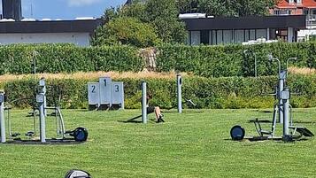 Un parc équipé d’appareils de musculation, de vélos et d’une poussette.