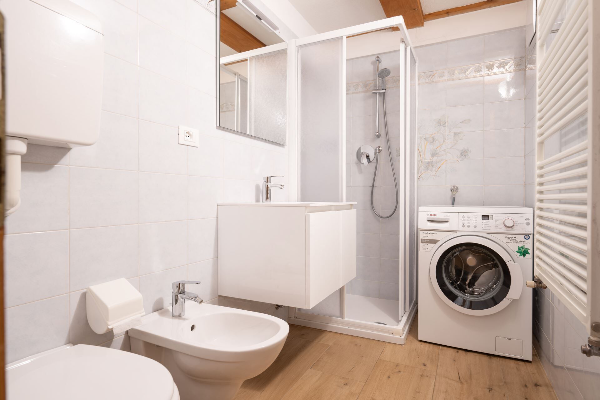 Ein modernes Badezimmer mit Dusche, Toilette, Bidet und Waschmaschine.
