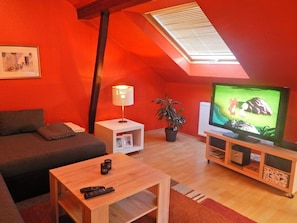 A cozy living room with a sofa, a coffee table, a TV, a lamp, and a potted plant. - Holiday Apartment 'Ferienhaus Rheinblick Wohnung 4' with Shared Terrace, Wi-Fi and Air Conditioning (Koblenz)