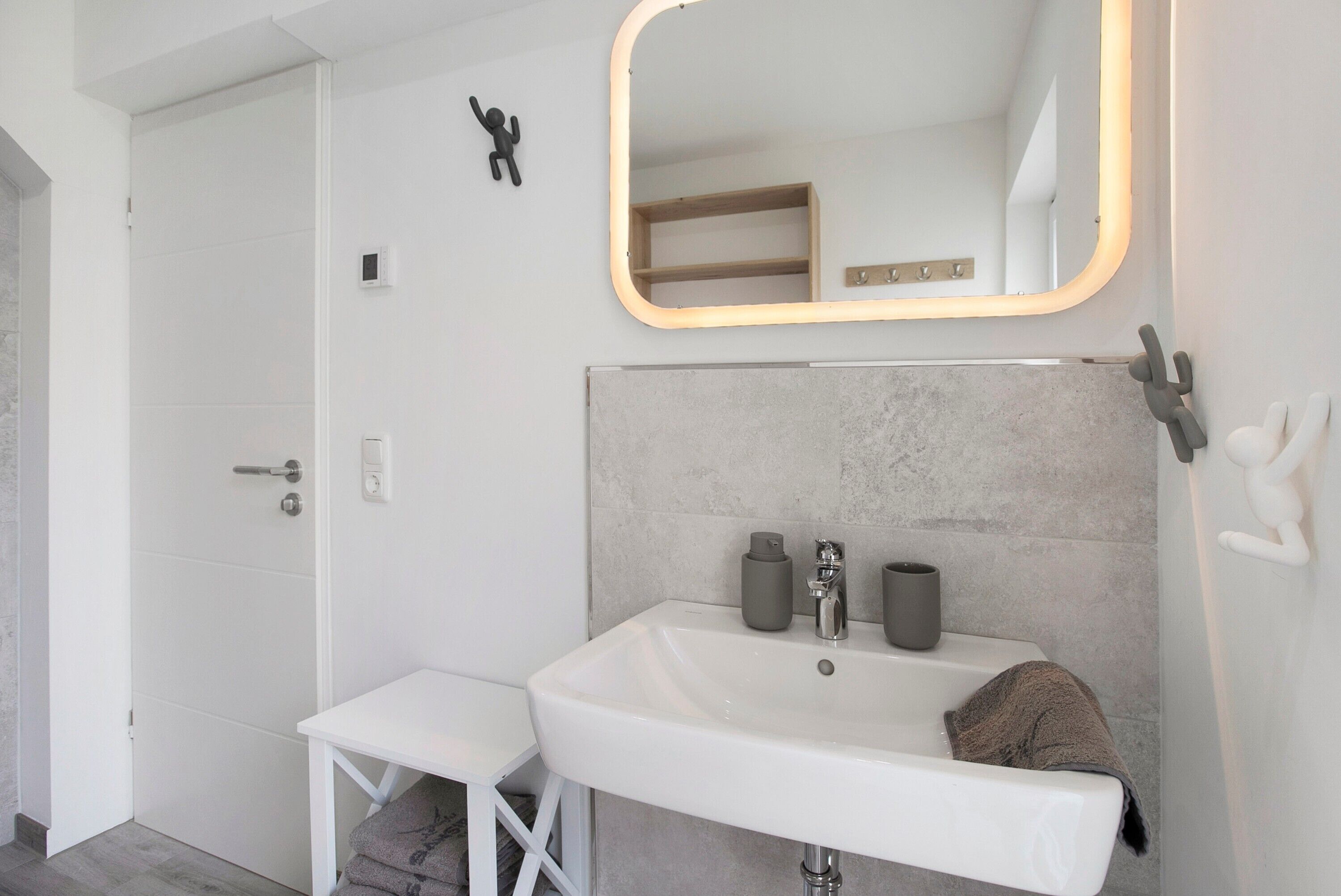 A bathroom with a white sink, a mirror with a wooden frame, and a towel on the counter.