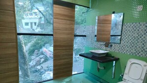 A bathroom with a toilet, sink, and mirror. - Hotel Lake In Tree (Nainital)