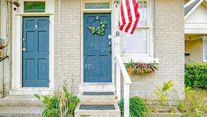 A house with two blue doors, a front porch with steps, a small window with an American flag, and a mailbox. - Charming Midtown Apt - Hannon Hideaway Unit B (Mobile)