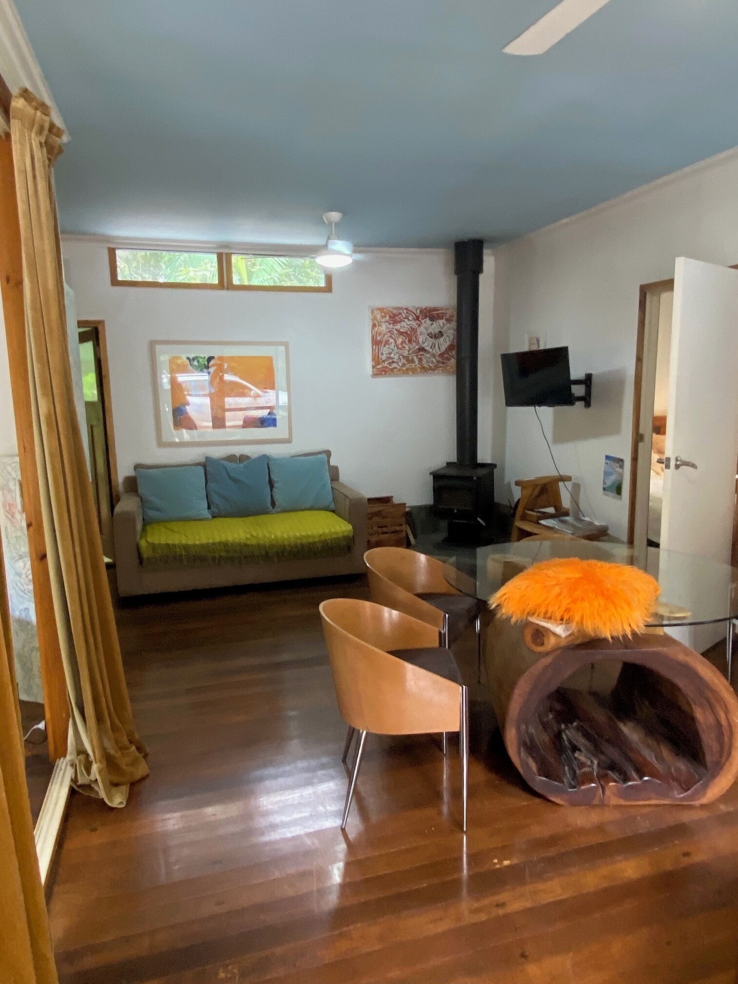 Un salon comprenant un canapé, des fauteuils, un téléviseur, une cheminée et un ventilateur de plafond.