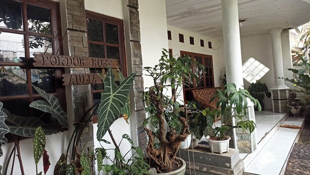A building with a sign reading "PONDOK KOALA ALAIA" and multiple potted plants. - OYO Life 91339 Pondok Kost Aulia Syariah (Garut)