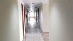 A long, narrow hallway with a tiled floor and white walls. - OYO Life 93374 Andira Inn (Depok)