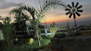 A windmill, palm trees, and a view of the sea at sunset. - Addauro Villa (Alcamo Marina)