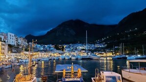 A marina with boats docked, a mountainous backdrop, and buildings along the waterfront. - Addauro Villa (Alcamo Marina)