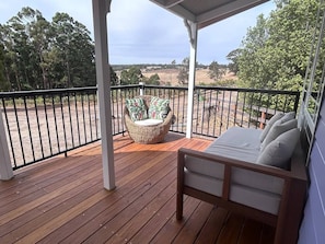A wooden deck with a wicker chair and a bed with pillows. - Belmira Vines
 Private Vineyard Escape! (Kangaroo Gully)