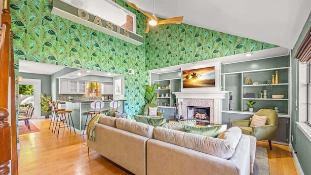A spacious living area with a large sofa, a fireplace, and a kitchen in the background.