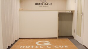 Een hotelentree met een deurmat waarop 