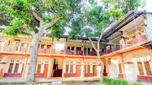 A multi-story building with balconies, a covered walkway, and a courtyard. - OYO Life 93257 Kos Anugerah (Mataram)