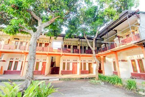 A multi-story building with balconies, a covered walkway, and a courtyard.