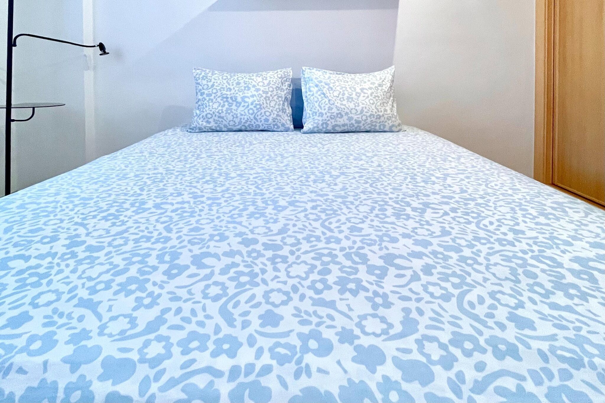 Una cama con una colcha estampada y dos almohadas a juego.
