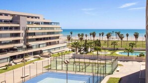 A modern hotel with multiple floors, a pool area, and a view of the beach. - Apartment in Roquetas near the Beach (Roquetas de Mar)