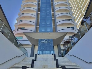 Welcome to Tramonto, where a grand staircase leads to the main entrance, flanked by balconies on each floor.