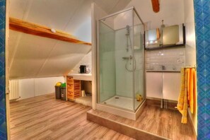 Een douche, handdoeken, shampoo, toiletpapier