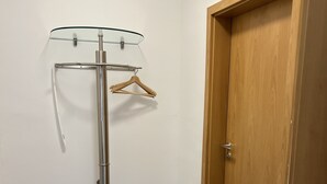 A room with a coat rack, a wooden door, and a tiled floor. - Apartment 170 (Bad Münstereifel)