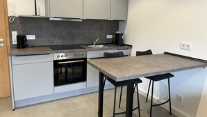 A compact kitchen with a built-in oven, a coffee maker, and a sink. - Apartment 170 (Bad Münstereifel)