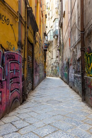 Ein schmaler Gang mit Graffiti an den Wänden und einem Fliesenboden.
