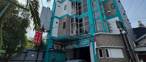 A multi-story building with a sign for 'COZY CENTRE RESIDENCE S'.