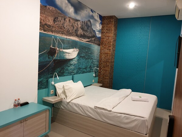 A bedroom with a bed, a nightstand, a wall-mounted TV, and a mural of a boat on water. - COZY CENTRE RESIDENCE SEMARANG (Semarang)