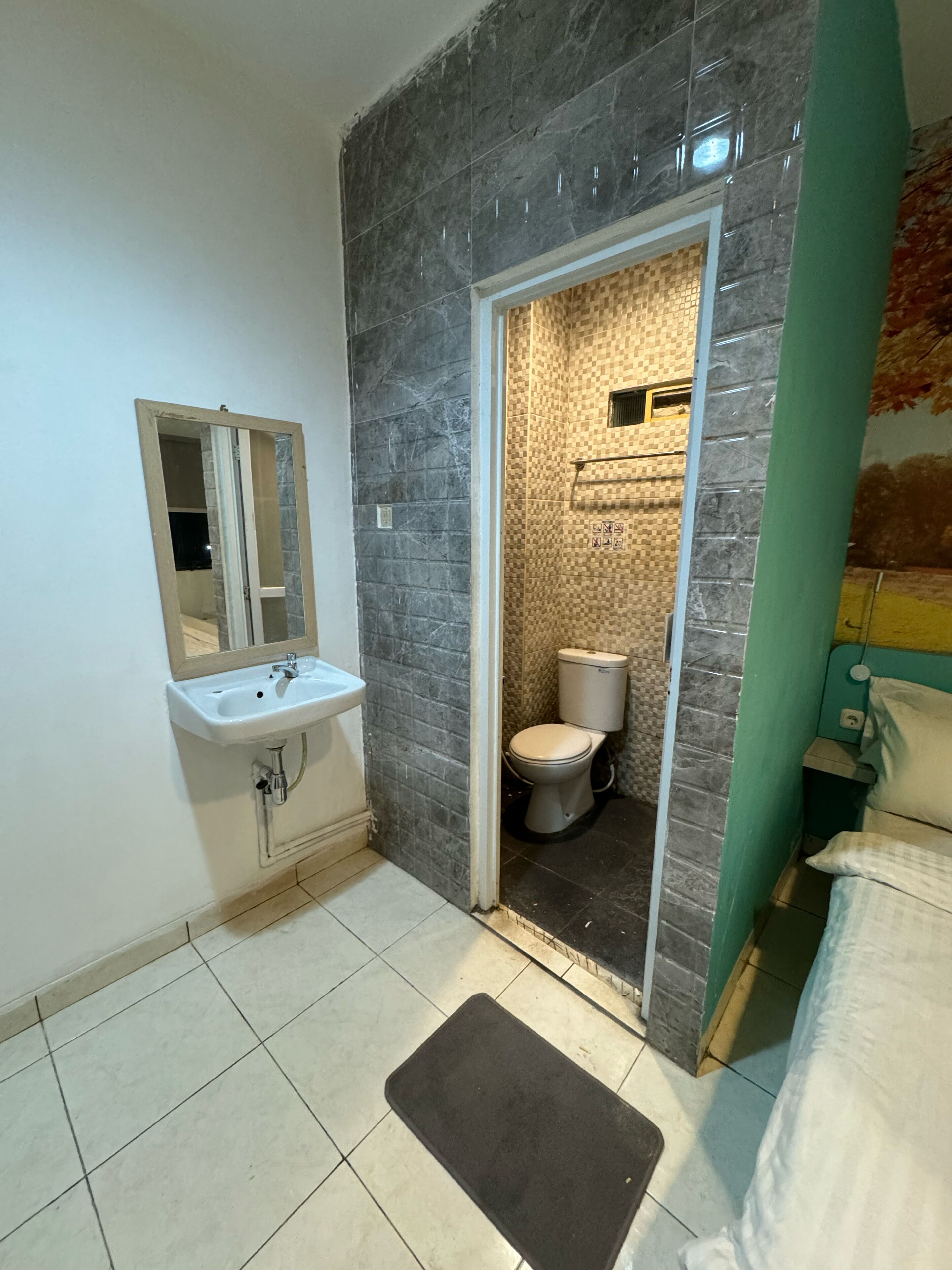 A bathroom with a white sink, a mirror, a toilet, and a shower area.