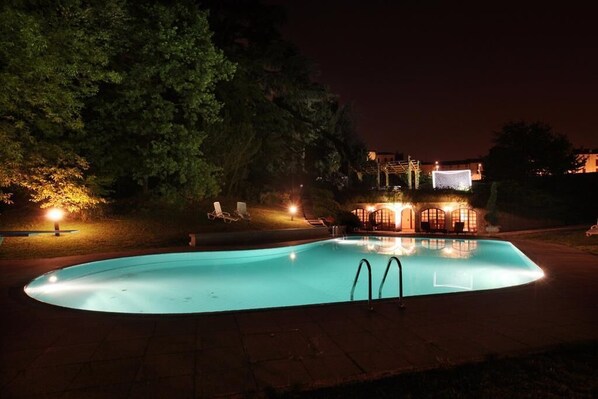 Una piscina al aire libre de temporada, sombrillas