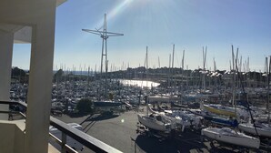 A marina with numerous boats docked, a clear sky, and a sun shining brightly. - Ile aux Moines (Arzon)