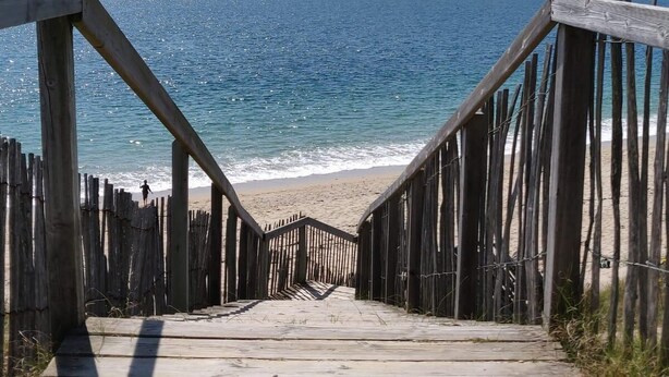 A wooden boardwalk leading to a beach with the ocean in the background. - Ile aux Moines (Arzon)