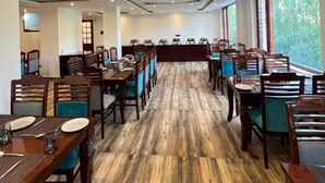 Un comedor amplio con suelo de madera y varias mesas y sillas.