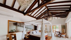 Un dormitorio espacioso con cama con dosel, vigas de madera, dosel y un espejo grande.