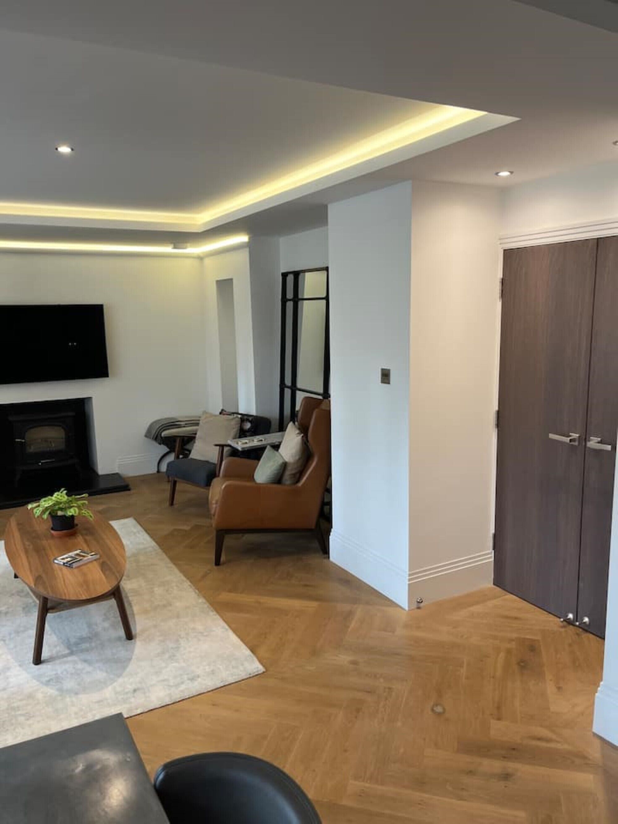 A modern living room with a fireplace, a television, and a dining area.
