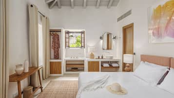 Un dormitorio con una cama, un tocador, un espejo, una ventana y una puerta.