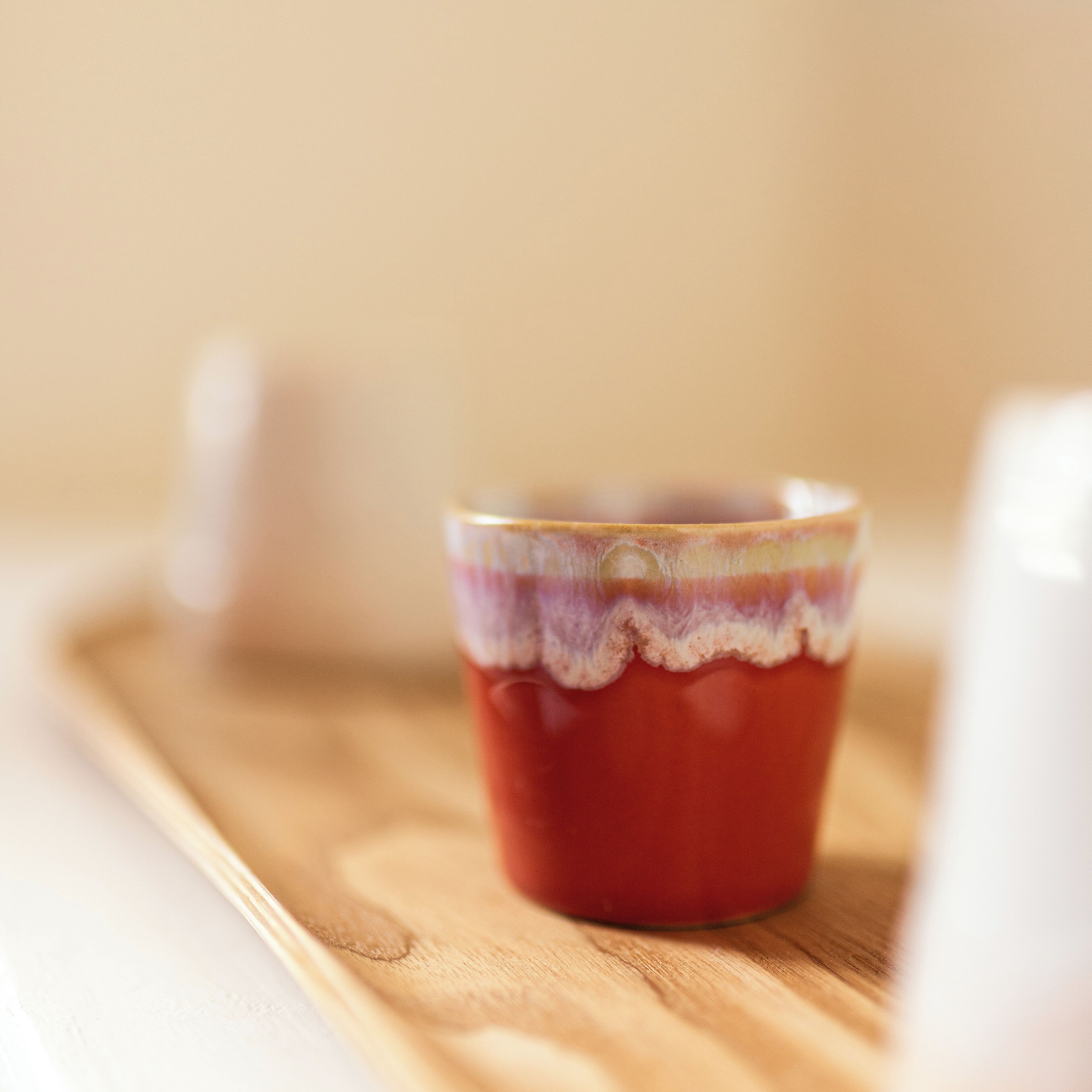 A ceramic mug with a textured pattern on a wooden tray.