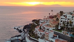 A coastal town with buildings along the sea, a clear sky, and a sunset. - Opal Moon, Santiago del Teide (Santiago del Teide)