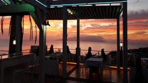 An outdoor seating area with tables and chairs, overlooking a sunset view. - Tess Dreamlike Mirador with Panoramic Views (Costa Adeje)