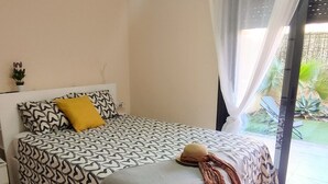 Ein Schlafzimmer mit einem gemusterten Bettbezug, einem gelben Kissen und einem dekorativen Gegenstand auf dem Bett.