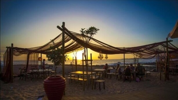 Ein Restaurant am Strand mit Außenbereich und Blick auf den Sonnenuntergang.