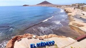 A coastal view with a beach, a mountain in the background, and the text "EL MEDANO" indicating the location. - CM 2 bd near the sea (El Médano)