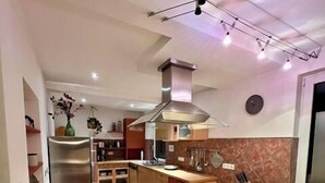 A modern kitchen with a central island, stainless steel appliances, and a large window. - Ferienwohnung Baalmann Nr. 4 (Borkum)