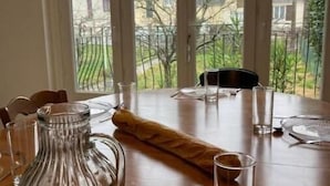 Een eettafel gedekt voor twee personen, met een karaf, glazen en een uitgerold menu.