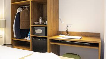 Een hotelkamer met een bed, een bureau, een kledingkast en een stoel.