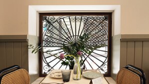 A dining table with a vase of flowers, plates, and cutlery. - Casa Pince (Barcelona)