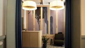 A reception area with a counter, a chair, and a potted plant. - Casa Pince (Barcelona)