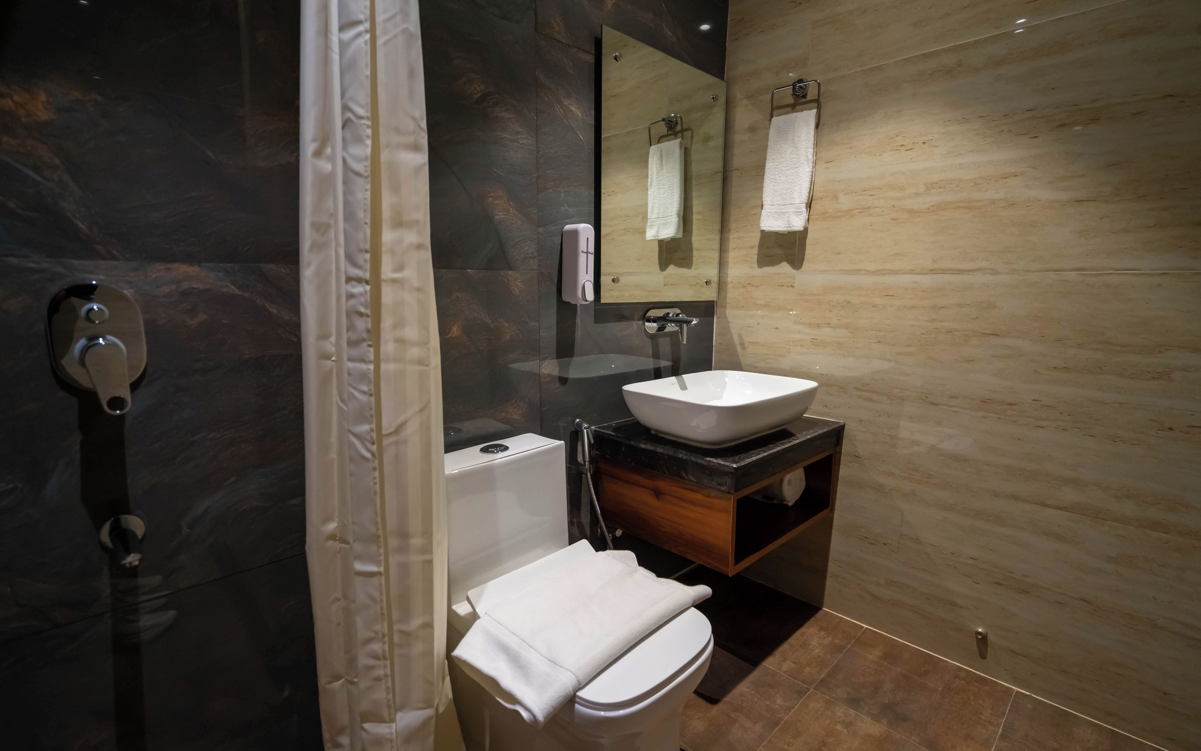 Un baño moderno con inodoro, lavamanos y ducha.