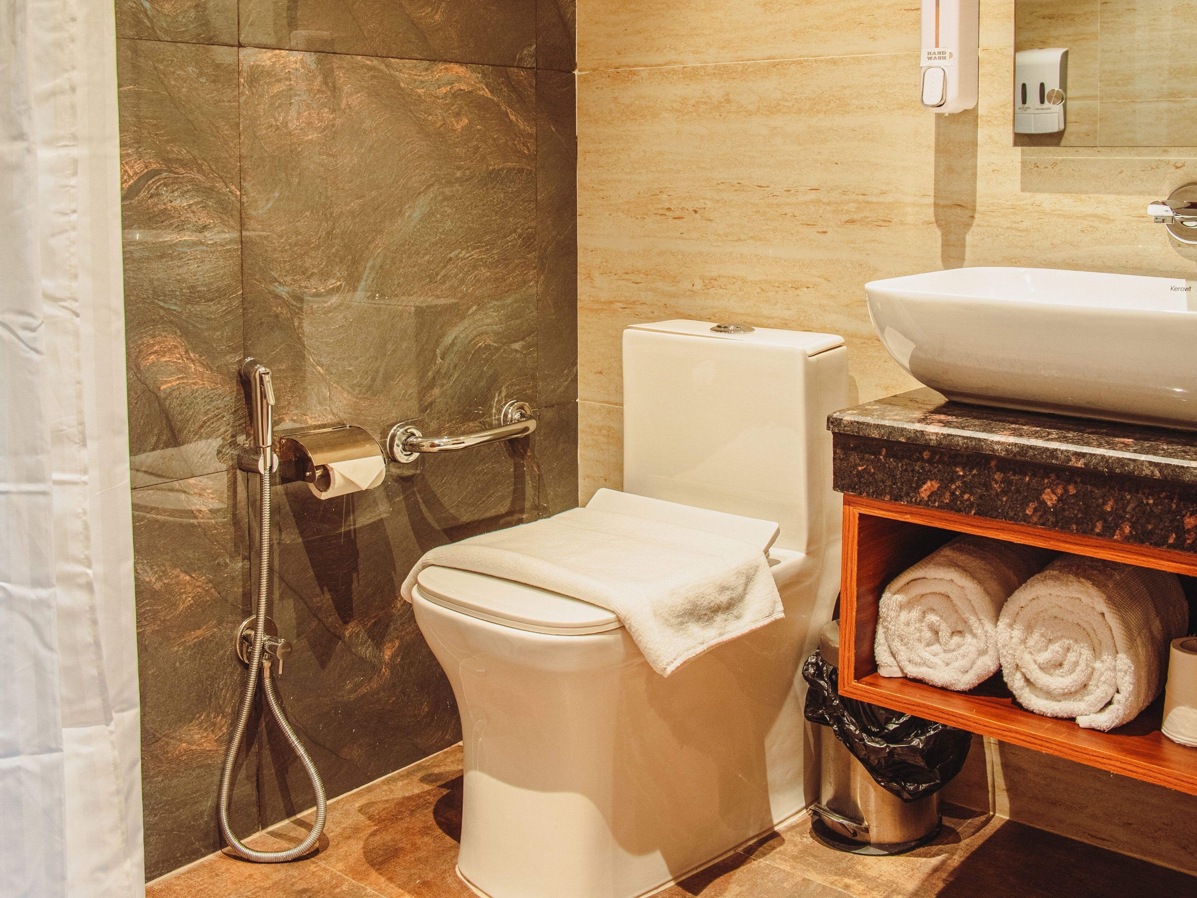 Une salle de bain équipée de toilettes, d’une douche, d’un lavabo et d’un porte-serviettes avec des serviettes.