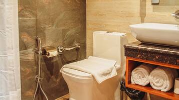 Une salle de bain équipée de toilettes, d’une douche, d’un lavabo et d’un porte-serviettes avec des serviettes.