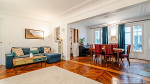 Ein geräumiges Wohnzimmer mit einer Couch, einem Esstisch und Stühlen.