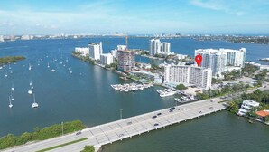 Vue aérienne d’une ville côtière avec un port de plaisance, des immeubles de grande hauteur et un pont.