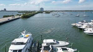 Un port de plaisance avec des bateaux amarrés, un pont et un bâtiment situé au loin.